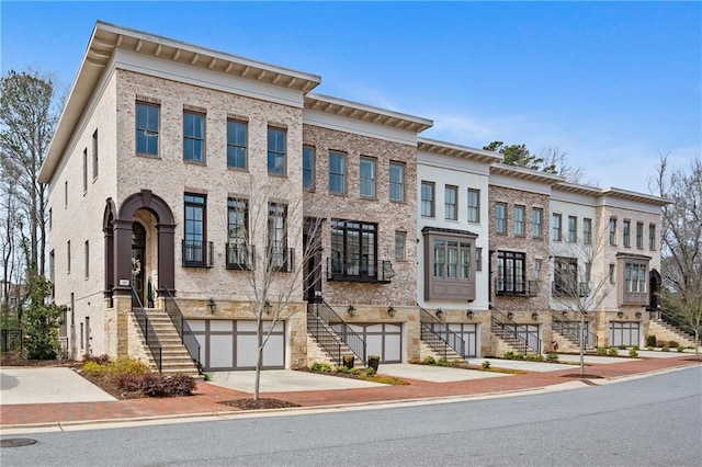multi unit property featuring stairs, an attached garage, and driveway