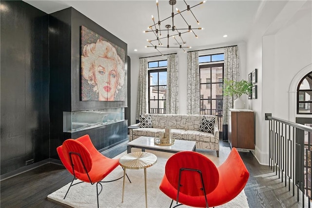 living area with wood finished floors, recessed lighting, baseboards, and a chandelier