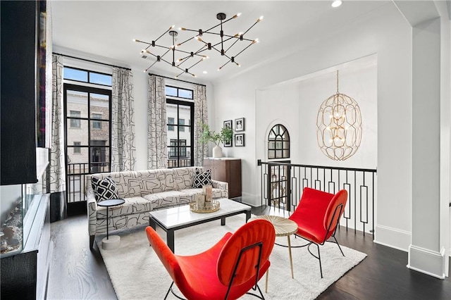 living room featuring recessed lighting, baseboards, an inviting chandelier, and wood finished floors