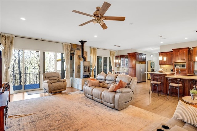 living room with ceiling fan, light wood-style flooring, and recessed lighting