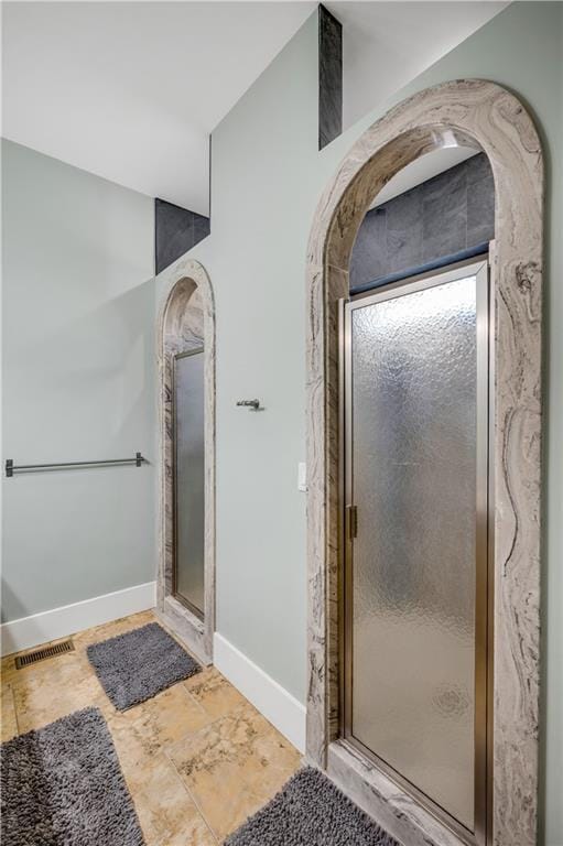 full bathroom with a shower stall, visible vents, and baseboards