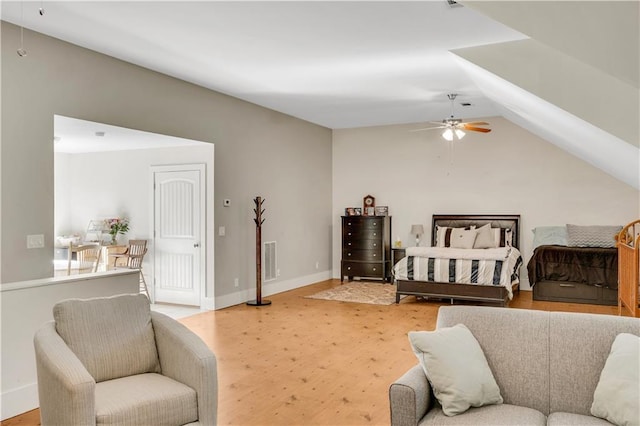 bedroom with lofted ceiling, a ceiling fan, visible vents, baseboards, and light wood finished floors