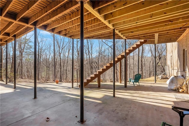 view of patio / terrace featuring stairway and a wooded view