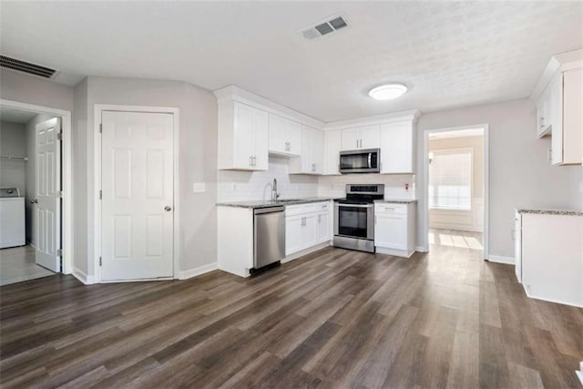 kitchen featuring white cabinetry, sink, washer / dryer, and stainless steel appliances