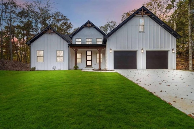 modern farmhouse style home with a garage, driveway, board and batten siding, and a front yard