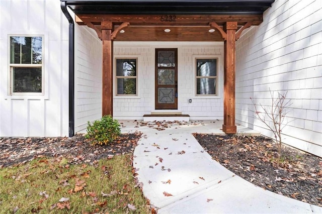 view of exterior entry featuring a porch and board and batten siding