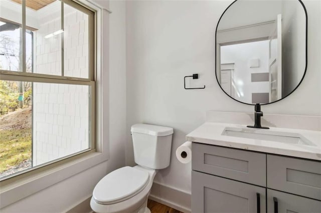 bathroom featuring vanity, toilet, and baseboards