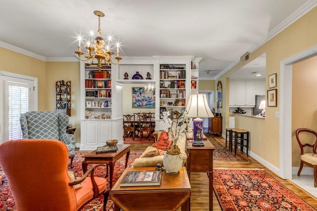 sitting room featuring light hardwood / wood-style flooring, crown molding, and a chandelier