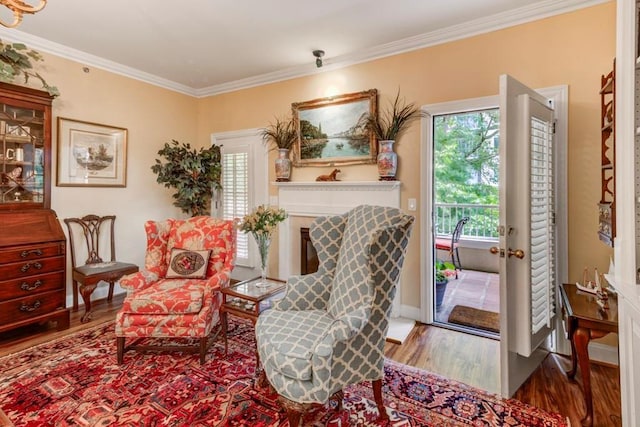 sitting room with wood-type flooring and ornamental molding