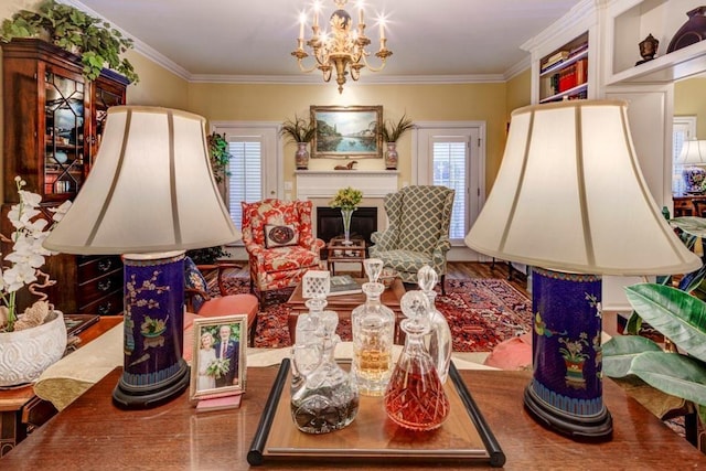 living room featuring hardwood / wood-style flooring, plenty of natural light, ornamental molding, and a notable chandelier