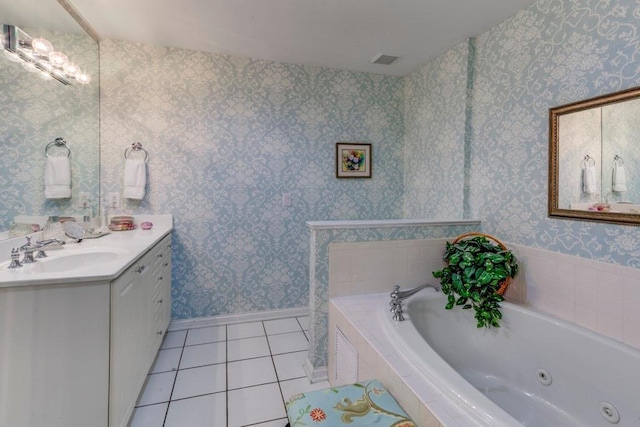 bathroom with tile patterned floors, vanity, and tiled tub