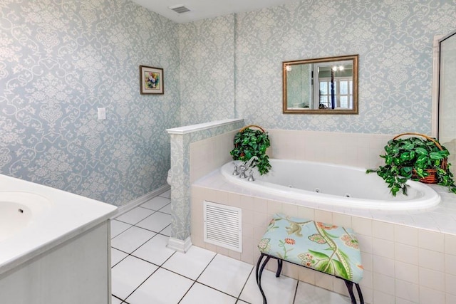 bathroom with tile patterned flooring, vanity, and a relaxing tiled tub