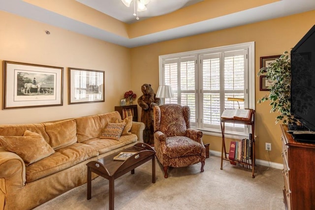 carpeted living room featuring plenty of natural light, ceiling fan, and a tray ceiling