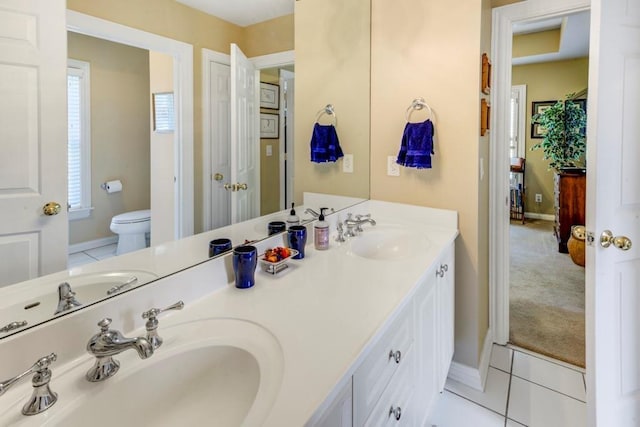 bathroom with tile patterned flooring, vanity, and toilet