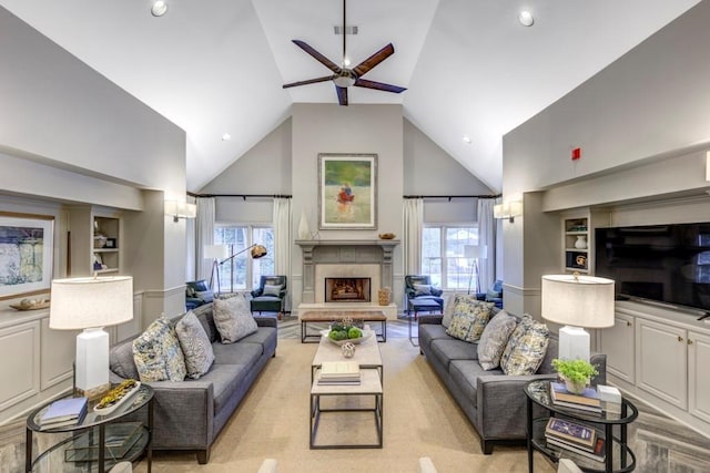 living room with built in shelves, high vaulted ceiling, and ceiling fan