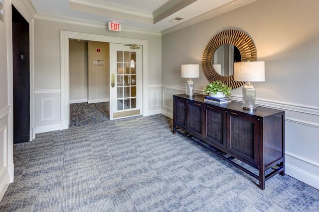 corridor with carpet, a raised ceiling, and ornamental molding