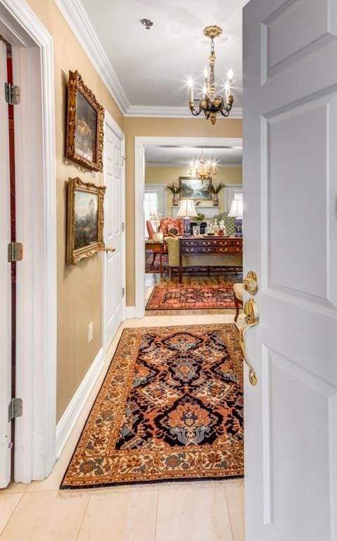 hall featuring a chandelier, tile patterned floors, and ornamental molding