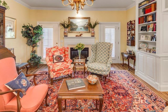 living area with a chandelier, light hardwood / wood-style floors, plenty of natural light, and crown molding