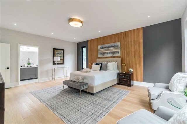 bedroom featuring recessed lighting, baseboards, wood walls, and light wood finished floors