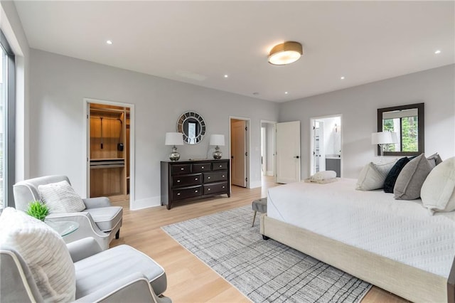 bedroom featuring recessed lighting, baseboards, ensuite bath, and light wood finished floors