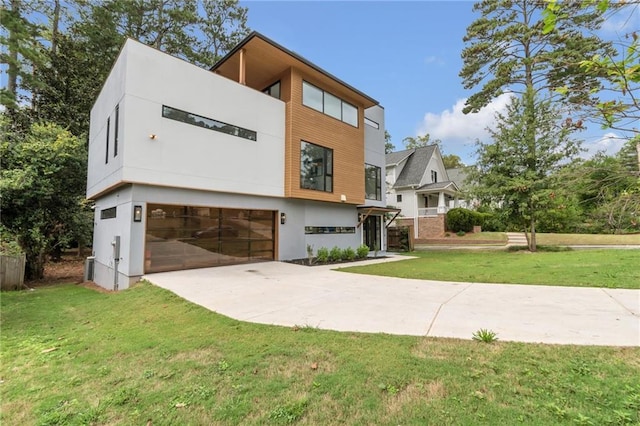 view of front of property with a garage, stucco siding, driveway, and a front lawn