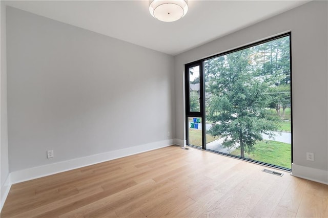 spare room with visible vents, baseboards, and light wood-style flooring