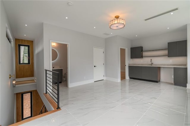 interior space with visible vents, marble finish floor, a sink, recessed lighting, and baseboards