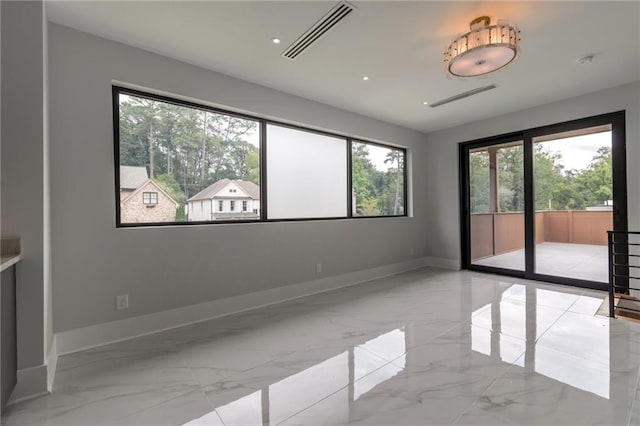 empty room featuring visible vents, marble finish floor, and baseboards