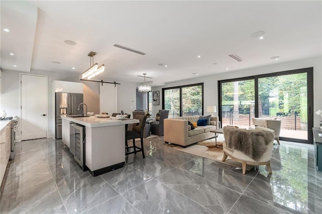 kitchen with a sink, visible vents, marble finish floor, and light countertops