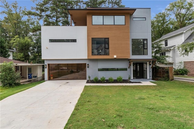 contemporary house featuring a garage, stucco siding, concrete driveway, and a front yard