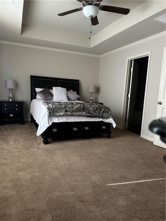 302 Turtle Creek Dr, Winder, GA 30680 - carpeted bedroom with a tray ceiling, crown molding, ceiling fan, and baseboards