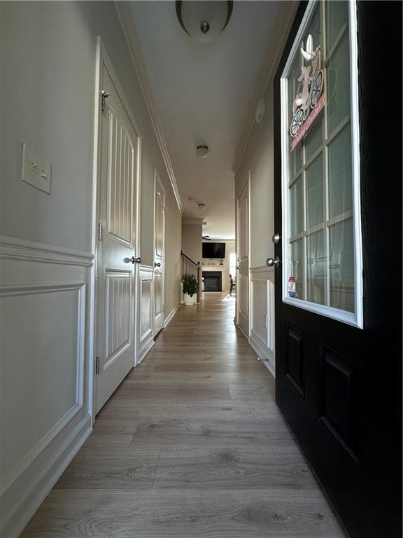 302 Turtle Creek Dr, Winder, GA 30680 - hall with a decorative wall, ornamental molding, light wood-style floors, and wainscoting