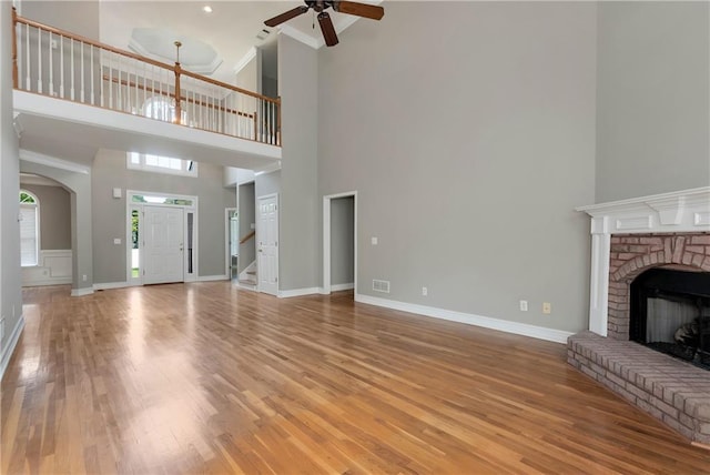 3885 Lake Juliette Dr, Buford, GA 30519 - unfurnished living room with ceiling fan, a towering ceiling, light wood finished floors, stairs, and ornamental molding
