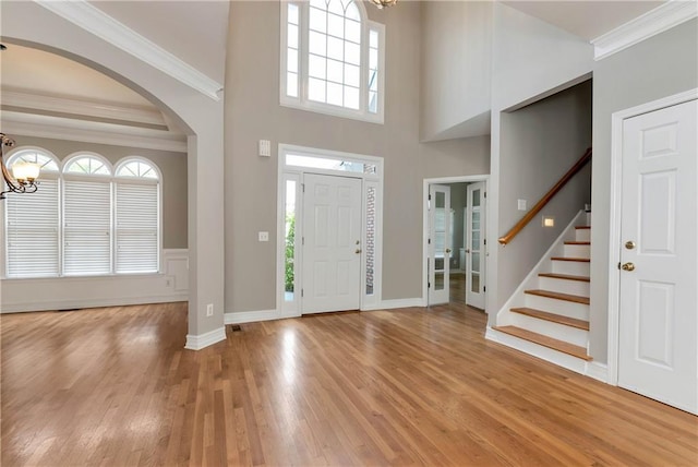 3885 Lake Juliette Dr, Buford, GA 30519 - entrance foyer with a chandelier, arched walkways, light wood finished floors, crown molding, and stairs
