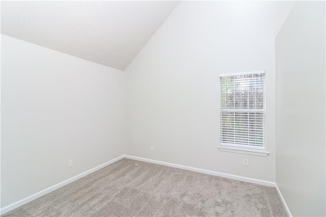 carpeted empty room featuring high vaulted ceiling