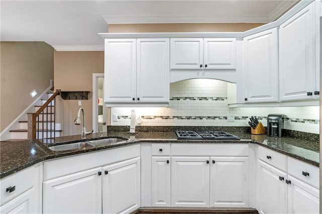 5396 Turnbill Pt NW, Acworth, GA 30101 - kitchen with stainless steel gas stovetop, backsplash, white cabinetry, dark stone countertops, and ornamental molding