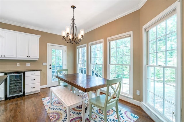 5396 Turnbill Pt NW, Acworth, GA 30101 - dining space featuring wine cooler, a chandelier, dark wood-style floors, plenty of natural light, and ornamental molding