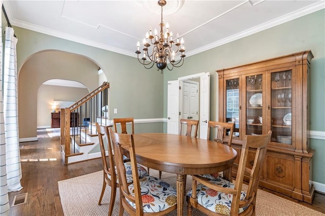 5396 Turnbill Pt NW, Acworth, GA 30101 - dining space with arched walkways, dark wood-style floors, a chandelier, and ornamental molding