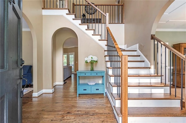 5396 Turnbill Pt NW, Acworth, GA 30101 - entryway featuring a high ceiling, wood finished floors, stairs, ornamental molding, and arched walkways