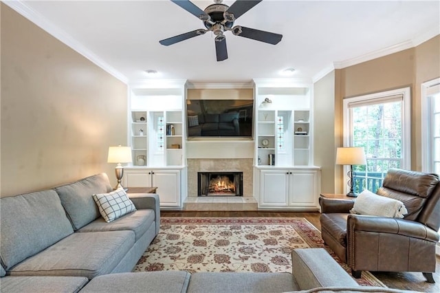 5396 Turnbill Pt NW, Acworth, GA 30101 - living area with wood finished floors, crown molding, a ceiling fan, a fireplace, and built in shelves