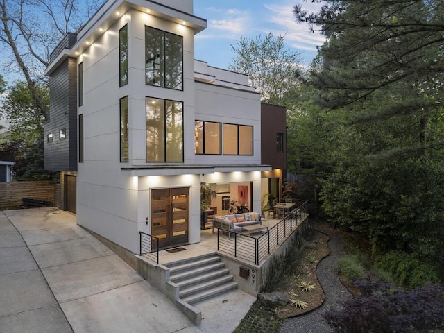 back house at dusk featuring an outdoor hangout area