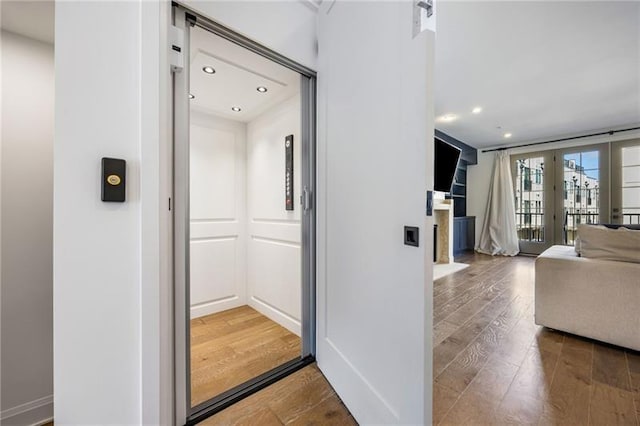 726 Edgewood Ave NE, Atlanta, GA 30307 - corridor with recessed lighting, a barn door, elevator, baseboards, and wood finished floors