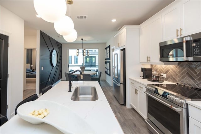 392 Pratt Dr Unit 2014, Atlanta, GA 30315 - kitchen featuring stainless steel appliances, dark wood-type flooring, white cabinets, backsplash, and recessed lighting
