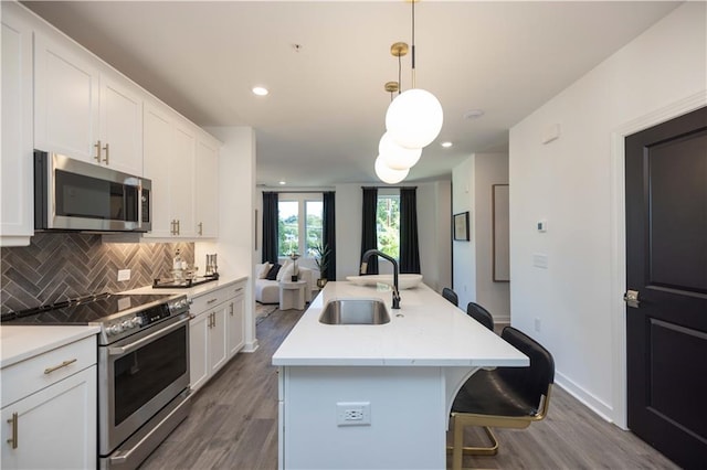 392 Pratt Dr Unit 2014, Atlanta, GA 30315 - kitchen with appliances with stainless steel finishes, wood finished floors, tasteful backsplash, a breakfast bar area, and recessed lighting