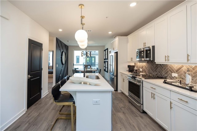 392 Pratt Dr Unit 2014, Atlanta, GA 30315 - kitchen with appliances with stainless steel finishes, backsplash, white cabinets, a kitchen island with sink, and recessed lighting