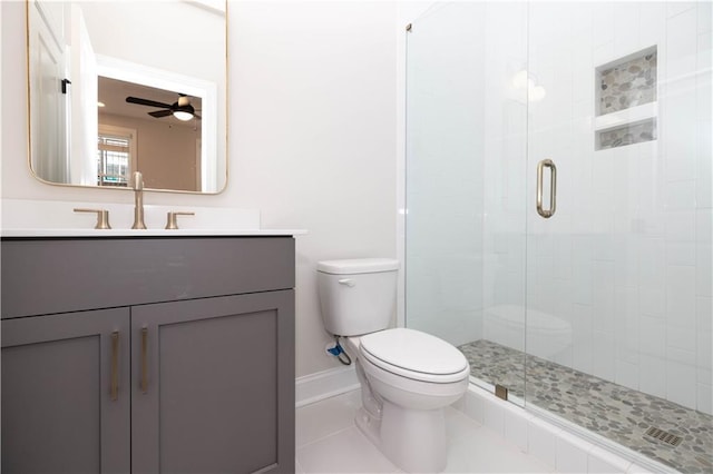 bathroom featuring toilet, vanity, a shower with door, ceiling fan, and tile patterned flooring