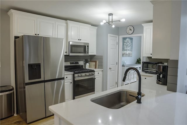 6985 Shane Ln, Cumming, GA 30028 - kitchen featuring stainless steel appliances, a sink, light countertops, and white cabinets