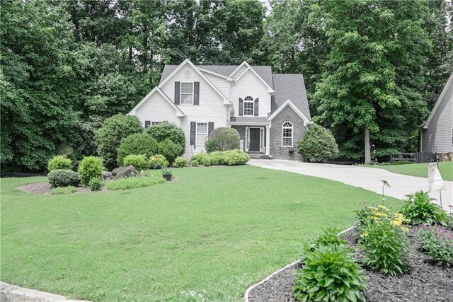 6985 Shane Ln, Cumming, GA 30028 - traditional-style home featuring a front lawn, stone siding, and view of scattered trees