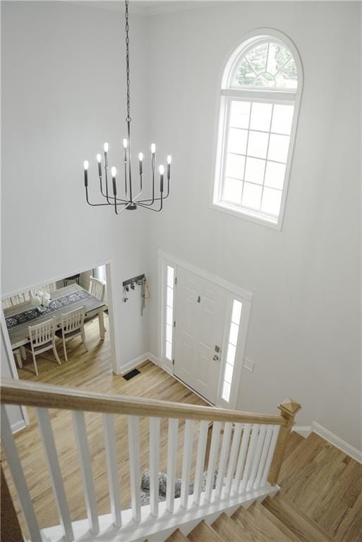 6985 Shane Ln, Cumming, GA 30028 - foyer with stairway, a towering ceiling, baseboards, light wood finished floors, and a chandelier