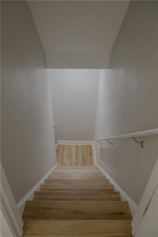 6985 Shane Ln, Cumming, GA 30028 - staircase featuring baseboards, wood finished floors, and lofted ceiling